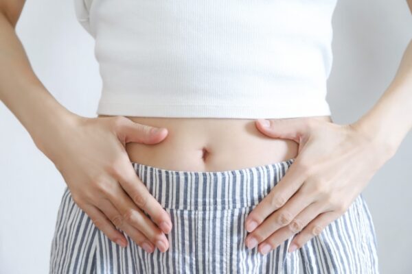 女性がお腹に手を当てる