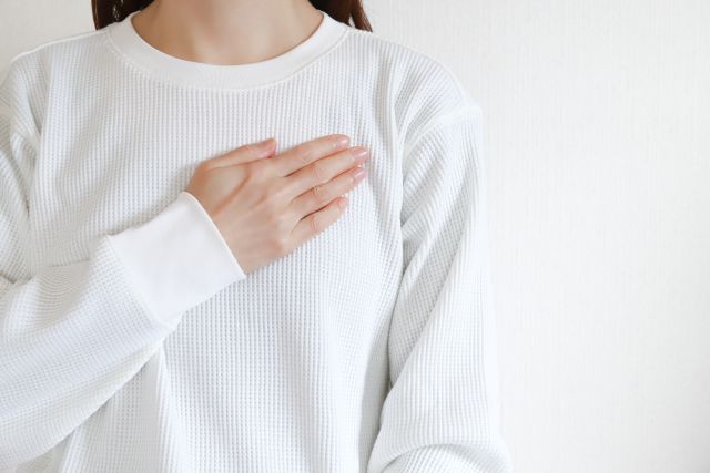女性が胸に手を当てている