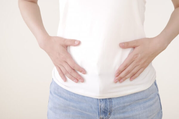 女性がお腹に手を当てている