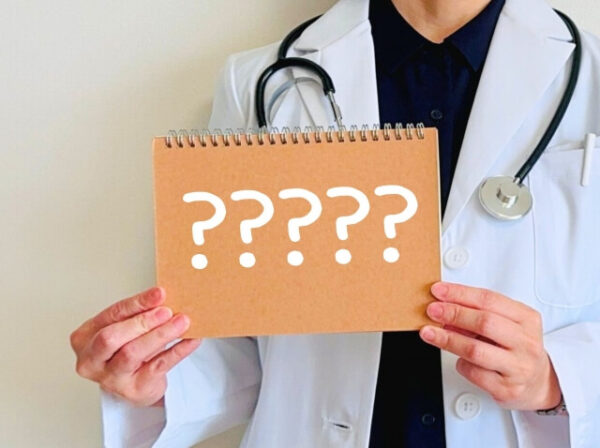 医師が？のボードを持っている